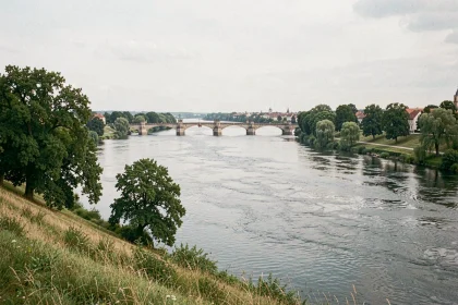 Vue panoramique du Danube serpentant à travers un paysage d'Europe centrale avec un pont médiéval en pierre au loin